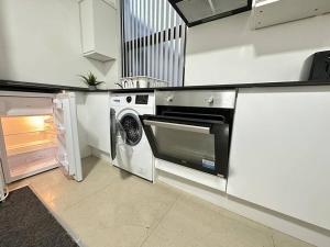 a kitchen with a microwave and a washer at Cosy Chic Flat in the Heart of Kidderminster in Kidderminster