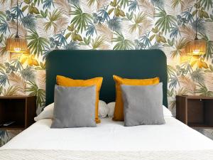 a bed with two pillows and a green headboard at La Casa de Carmen in Castilleja de la Cuesta