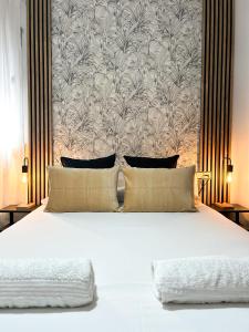 a bedroom with a large white bed with a wallpaper at La Casa de Carmen in Castilleja de la Cuesta