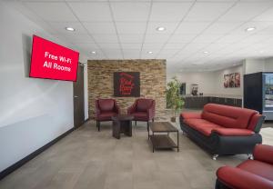 a lobby with a red couch and chairs and a sign at Red Roof Inn Lancaster, TX in Lancaster