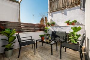 een balkon met een tafel, stoelen en planten bij family vacation in Jeruzalem