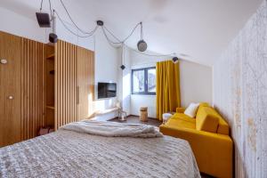 a bedroom with a bed and a yellow couch at Apartmán Prkenný důl in Prkenný Dŭl