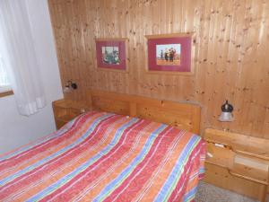 - une chambre avec un lit et deux photos sur le mur dans l'établissement Ferienhaus für 6 Personen ca 42 qm in Bibione, Adriaküste Italien Bibione und Umgebung, à Bibione