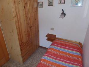 - une petite chambre avec un lit et une porte en bois dans l'établissement Ferienhaus für 6 Personen ca 42 qm in Bibione, Adriaküste Italien Bibione und Umgebung, à Bibione