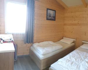 a room with two beds in a wooden cabin at Park Jesionów domki - Pleśna in Pleśna