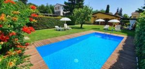 una piscina en un patio con sillas y sombrillas en Ferienhaus mit Privatpool für 2 Personen ca 65 qm in Capannori, Toskana Provinz Lucca, en Capannori