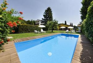 una piscina con sillas y sombrillas en un patio en Ferienhaus mit Privatpool für 2 Personen ca 65 qm in Capannori, Toskana Provinz Lucca, en Capannori