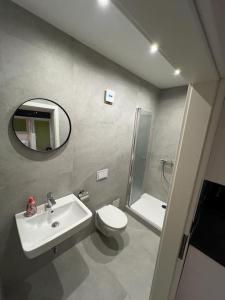a bathroom with a sink and a toilet and a mirror at Innenstadtwohnung mit Klima - RMI 1 in Wiener Neustadt