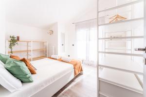 Habitación blanca con cama y estanterías en Attico Mirage en Verona