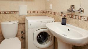 a bathroom with a washing machine and a sink at roomspoznan pl - Powstancow Wielkopolskich 23 - 24h self check-in in Poznań