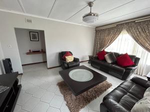 uma sala de estar com sofás e uma mesa de centro em Zinoma guest house em Empangeni