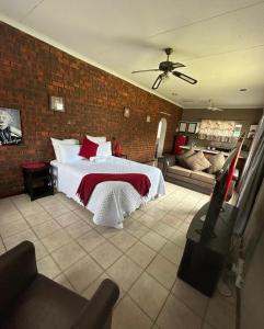 um quarto com uma cama e uma parede de tijolos em Zinoma guest house em Empangeni