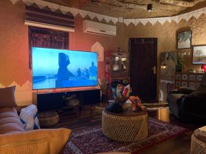 sala de estar con TV de pantalla plana grande en Majed Chalet, en Riad