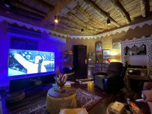 sala de estar con TV grande en una habitación con iluminación púrpura en Majed Chalet, en Riad