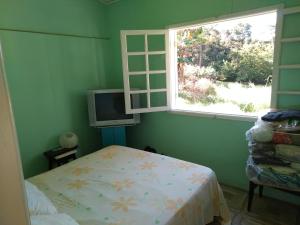 um pequeno quarto com uma cama e uma janela em Joanopolis Inn - Mantiqueira 1 em Joanópolis