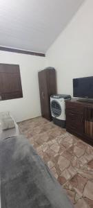 Il comprend un salon doté d'une télévision et de carrelage. dans l'établissement Casa Recanto Coqueiral, à Porto Seguro