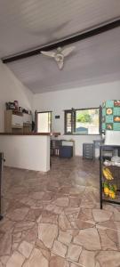 un grand salon avec un ventilateur de plafond et un sol en pierre dans l'établissement Casa Recanto Coqueiral, à Porto Seguro