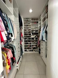 - un dressing avec des étagères et des chaussures blanches dans l'établissement casa en samborondon, à Guayaquil