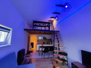 Una habitación con una escalera con sillas y una mesa. en Apartament Chojnice, en Chojnice