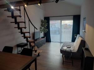 sala de estar con escalera de caracol y sofá en Apartament Chojnice, en Chojnice