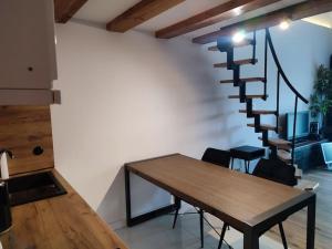 comedor con mesa y escalera de caracol en Apartament Chojnice, en Chojnice 1 foto más