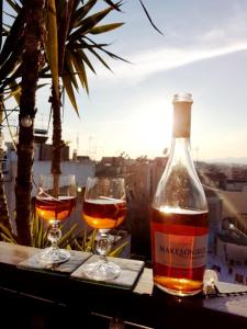 a bottle of wine and two glasses on a table at Αfrodite! Roof top studio--Wonderful city view in Athens