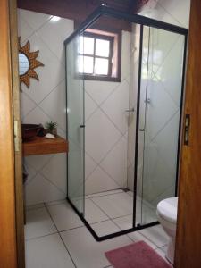 a glass shower in a bathroom with a toilet at Hygge Sunset House in Ilha do Mel