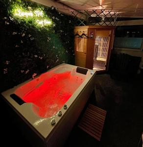 une baignoire remplie d'eau rouge dans la cour dans l'établissement L’Escapade SPA Sauna + Jacuzzi, à Saint-Brieuc