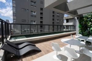 a balcony with a table and chairs on a building at Boulevard Ibirapuera in São Paulo