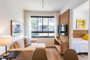 a small living room with a bed and a couch at Boulevard Ibirapuera in São Paulo