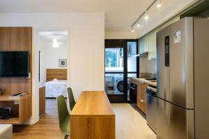 a kitchen with a wooden table and a refrigerator at Boulevard Ibirapuera in São Paulo