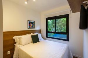 a bedroom with a white bed and a window at Boulevard Ibirapuera in São Paulo +193 photos