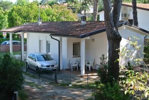 ein weißes Haus mit einem davor geparkt in der Unterkunft Ferienhaus für 5 Personen ca 35 qm in Bibione, Adriaküste Italien Bibione und Umgebung - b62945 in Bibione