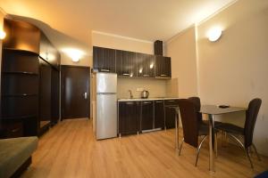a kitchen with a refrigerator and a table with chairs at BATUMi WELLCOME ORBI APART HOTEL in Angisa