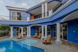 a blue house with chairs and a swimming pool at Gran Pacifica Beach Resort & Homes in San Diego