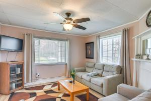 ein Wohnzimmer mit einem Sofa und einem Deckenventilator in der Unterkunft Charming Fayetteville Home with Deck and Grill! in Fayetteville