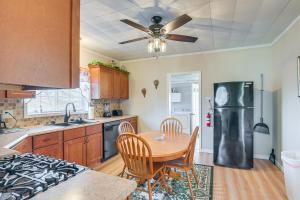 La cuisine est équipée d'une table et d'un réfrigérateur en acier inoxydable. dans l'établissement Charming Fayetteville Home with Deck and Grill!, à Fayetteville