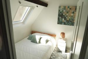 - une petite chambre avec un lit et une fenêtre dans l'établissement Le Petit Chartrain, à Chartres