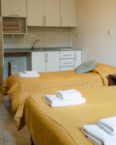 una cocina con 3 camas y toallas. en Folk Suites en El Calafate