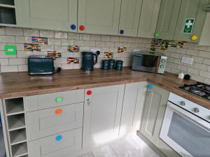 a kitchen with white cabinets and a wooden counter top at The Lego themed house in Windsor