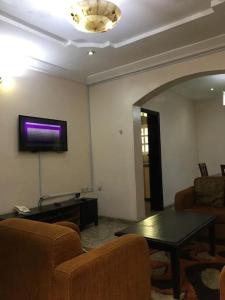sala de estar con mesa y TV en la pared en Cozy 2 bedroom serviced Apartment, en Calabar