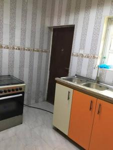 a kitchen with a sink and a stove at Cozy 2 bedroom serviced Apartment in Calabar