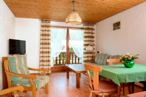 a living room with a table and chairs and a television at Ferienhaus Dickertsmühle in Prien am Chiemsee