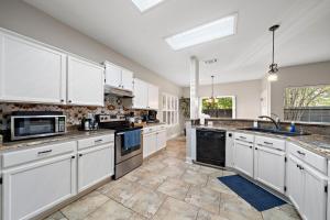 a large kitchen with white cabinets and appliances at Sa Golf Home Nr Six Flags Wi-fi Bbq Games in San Antonio