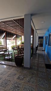 a hallway of a building with tables and chairs at POMMER POUSADA in Guriri