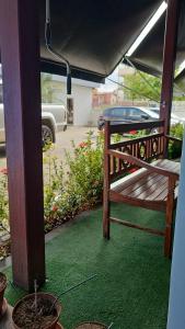 a porch with a bench and a green floor at POMMER POUSADA in Guriri