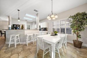 a kitchen and dining room with a white table and chairs at Sa Golf Home Nr Six Flags Wi-fi Bbq Games in San Antonio