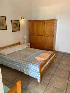 een slaapkamer met een bed en een houten kast bij Apartmani Nedic in Petrovac na Moru