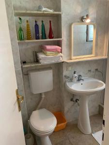 een badkamer met een toilet, een wastafel en een spiegel bij Apartmani Nedic in Petrovac na Moru