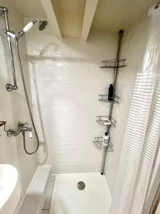 uma casa de banho com um chuveiro, um WC e um lavatório. em Charmant 2 pièces au cœur du Marais em Paris